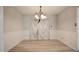 Dining room featuring neutral walls, a classic light fixture, and wood flooring at 601 Country Ln, Holly Springs, NC 27540