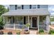 Inviting front porch with hanging ferns, white lattice, and comfortable seating area at 601 Country Ln, Holly Springs, NC 27540