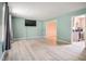 Open-concept living room featuring modern laminate flooring and seamless access to the adjacent kitchen at 601 Country Ln, Holly Springs, NC 27540