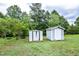 Two sheds offer extra storage space in a lush, green backyard surrounded by mature trees at 601 Country Ln, Holly Springs, NC 27540