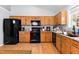 Functional kitchen with wood cabinets, black appliances, and laminate countertops at 601 Southampton Dr, Knightdale, NC 27545