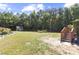 Large backyard featuring a storage shed, mature trees, and a wooden staircase leading to the back door at 6521 Sunset Manor Dr, Wake Forest, NC 27587