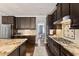 Well-equipped kitchen with dark wood cabinets, granite countertops, and stainless steel appliances at 6521 Sunset Manor Dr, Wake Forest, NC 27587