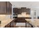 Gourmet kitchen featuring granite countertops, stainless steel appliances, and dark wood cabinetry at 6521 Sunset Manor Dr, Wake Forest, NC 27587