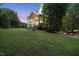 Expansive backyard featuring a well-maintained lawn, established trees, and an outdoor patio at 704 Walcott Way, Cary, NC 27519