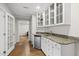 The bar area features granite countertops, white cabinetry, and a stainless steel mini-fridge for drinks at 704 Walcott Way, Cary, NC 27519