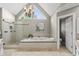 Beautiful bathroom featuring a large tub, glass shower, vaulted ceiling, and stunning chandelier at 704 Walcott Way, Cary, NC 27519