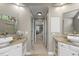 En-suite bathroom featuring dual granite vanities, framed mirrors, and tile flooring at 704 Walcott Way, Cary, NC 27519