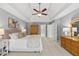 Bright bedroom featuring a neutral color palette, ceiling fan, and access to the en-suite bathroom at 704 Walcott Way, Cary, NC 27519