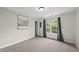 Bright bedroom with neutral paint, carpeted floor, a large window with backyard views and artwork on the wall at 704 Walcott Way, Cary, NC 27519