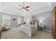 Spacious bedroom features tray ceilings, neutral walls, ceiling fan, and cozy sitting area at 704 Walcott Way, Cary, NC 27519