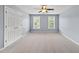 This spacious bedroom features neutral paint, carpeted floor, a ceiling fan, and double windows at 704 Walcott Way, Cary, NC 27519