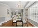 Cozy dining area with hardwood floors, a glass table, and a view of the inviting living room at 704 Walcott Way, Cary, NC 27519