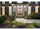 Inviting entryway with beautiful double doors, manicured landscaping, and classic brick facade with white columns at 704 Walcott Way, Cary, NC 27519