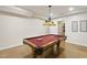 Spacious game room with vintage pool table, unique lighting, and hardwood floors at 704 Walcott Way, Cary, NC 27519