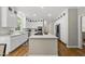 Modern kitchen with an island, stainless steel appliances, white cabinetry, and marble countertops at 704 Walcott Way, Cary, NC 27519
