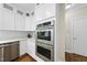 Modern kitchen with stainless steel appliances, white cabinetry, and marble countertops at 704 Walcott Way, Cary, NC 27519