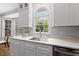Kitchen with white cabinets, marble countertops, stainless steel appliances, and a large window above the sink at 704 Walcott Way, Cary, NC 27519