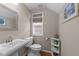 A well-lit half bathroom features a pedestal sink, decorative mirror, and modern fixtures at 7768 Berry Crest Ave, Raleigh, NC 27617
