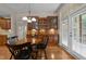 Charming dining area featuring a built-in bar with glass cabinets and a view of the backyard through French doors at 7768 Berry Crest Ave, Raleigh, NC 27617
