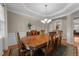 Formal dining room with a large wooden table, elegant chandelier, and decorative molding at 7768 Berry Crest Ave, Raleigh, NC 27617