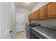 Functional laundry room with modern washer and dryer and ample cabinet storage at 7768 Berry Crest Ave, Raleigh, NC 27617