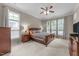 Spacious main bedroom with large windows, plush carpet, and an elegant ceiling fan for comfort at 7768 Berry Crest Ave, Raleigh, NC 27617