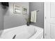 Bright white bathtub with chrome fixtures, towel rack and adjacent wall art enhance the soaking experience at 7807 Elmshire Way, Raleigh, NC 27616