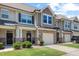 Attractive townhome featuring stone accents, a one-car garage, and a welcoming front porch area at 7807 Elmshire Way, Raleigh, NC 27616