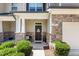 Inviting front entrance with stone accents, a charming wreath, and manicured landscaping at 7807 Elmshire Way, Raleigh, NC 27616