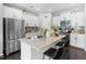 Bright kitchen features a large island with granite countertops, stainless steel appliances, and white cabinetry at 7807 Elmshire Way, Raleigh, NC 27616