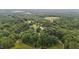 Expansive aerial view of a private estate surrounded by lush greenery, including a pond and sprawling lawns at 7918 Dairy Ridge Rd, Mebane, NC 27302