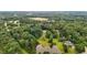 Overhead view of a secluded estate with a picturesque pond and a swimming pool nestled among mature trees at 7918 Dairy Ridge Rd, Mebane, NC 27302