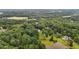 Picturesque aerial perspective of an estate with a pond, pool, and homesites nestled within a lush, wooded landscape at 7918 Dairy Ridge Rd, Mebane, NC 27302