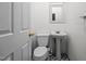 Small bathroom featuring a toilet, sink and mirror with tiled floors at 7918 Dairy Ridge Rd, Mebane, NC 27302