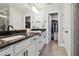 Bathroom with double sinks, granite counters, white cabinets, and a walk-in closet for ample storage at 805 Winter Meadow Dr, Wake Forest, NC 27587