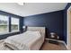 Bedroom with dark blue walls, a plush bed, and natural light from a window highlighting comfort and style at 805 Winter Meadow Dr, Wake Forest, NC 27587
