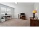 Neutral living room with large window, a work desk, and dark brown furniture at 805 Winter Meadow Dr, Wake Forest, NC 27587