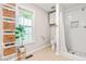 Bright bathroom featuring a tiled shower, storage shelves and a window at 8116 Owenston Ct, Raleigh, NC 27612