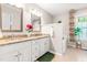 Well-lit bathroom with dual sinks, granite countertops, and a separate soaking tub at 8116 Owenston Ct, Raleigh, NC 27612