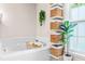 Bright bathroom featuring a soaking tub with woven storage shelves and natural light from a window at 8116 Owenston Ct, Raleigh, NC 27612