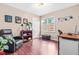 Bedroom with wooden floors, neutral walls, a window, a dark leather chair, and dark brown desk at 8116 Owenston Ct, Raleigh, NC 27612