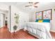 Bright bedroom with a ceiling fan, natural light, and neutral walls with framed floral wall decor at 8116 Owenston Ct, Raleigh, NC 27612