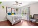 Bedroom featuring hardwood floors, a ceiling fan, natural light, and neutral walls with decorative art at 8116 Owenston Ct, Raleigh, NC 27612