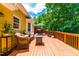 Inviting back deck featuring wicker seating, a fire pit, grill, and an umbrella covered dining table at 8116 Owenston Ct, Raleigh, NC 27612