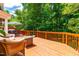 Spacious wood deck featuring a dining table, charcoal grill, outdoor seating, and peaceful views of the woods at 8116 Owenston Ct, Raleigh, NC 27612