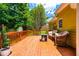 Relaxing deck area with comfortable wicker seating, an outdoor table, and a view of the backyard at 8116 Owenston Ct, Raleigh, NC 27612