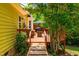 View of the deck from the backyard, showcasing the outdoor seating, table, umbrella, and access to the house at 8116 Owenston Ct, Raleigh, NC 27612