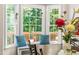 Sunlit dining area with bay window overlooking the outdoor deck and lush greenery at 8116 Owenston Ct, Raleigh, NC 27612