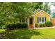 Charming yellow home with brick stairs, manicured shrubs and lush green lawn at 8116 Owenston Ct, Raleigh, NC 27612